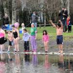 Seventeen brave souls line up on the shores of Lake Pleasant on New Years morning, waiting for Carin Hirschs ringing of the bell, indicating the start of the annual plunge. Another photo page 3. Photo by Lonnie Archibald