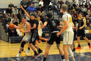 Photos by Lonnie Archibald 
Spartan Radly Bennett drives the lane against the Raymond-South Bend Ravens, who Forks defeated 64 to 53. Also in the action are Noah Foster and Ty Rowley.
