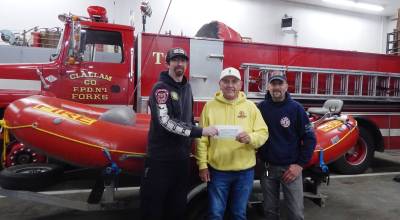 Photo Christi Baron 
Forks firemen, CCFD#1, Chris Martin (left) and Mike Zavadlov (right) accept a $1,000 donation from Ed Bedford (center) of Bedfords Craft Sodas of Port Angeles to support the departments swift water rescue program and its effort to purchase a jet boat. Zavadlov noted the department responded to five boat flips this winter, including one fatal incident. Bedford made the contribution in memory of his friend John Brewer, former publisher of the Peninsula Daily News, Sequim Gazette and Forks Forum, who died in April 2024 in a Montana fly-fishing accident when the boat he was in struck a submerged log and overturned. The team currently relies on a neighboring jurisdiction for access to a jet boat. The Swift Water Team continues fundraising efforts through a GoFundMe campaign.