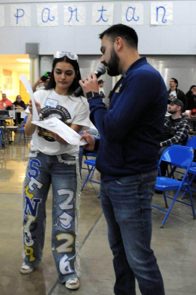 Photo Lonnie Archibald 
Skye Hestand and Ismael Ramos go over items to be auctioned. Skye leaves us no doubt that she is a senior of the class of 2026 by her clothing.