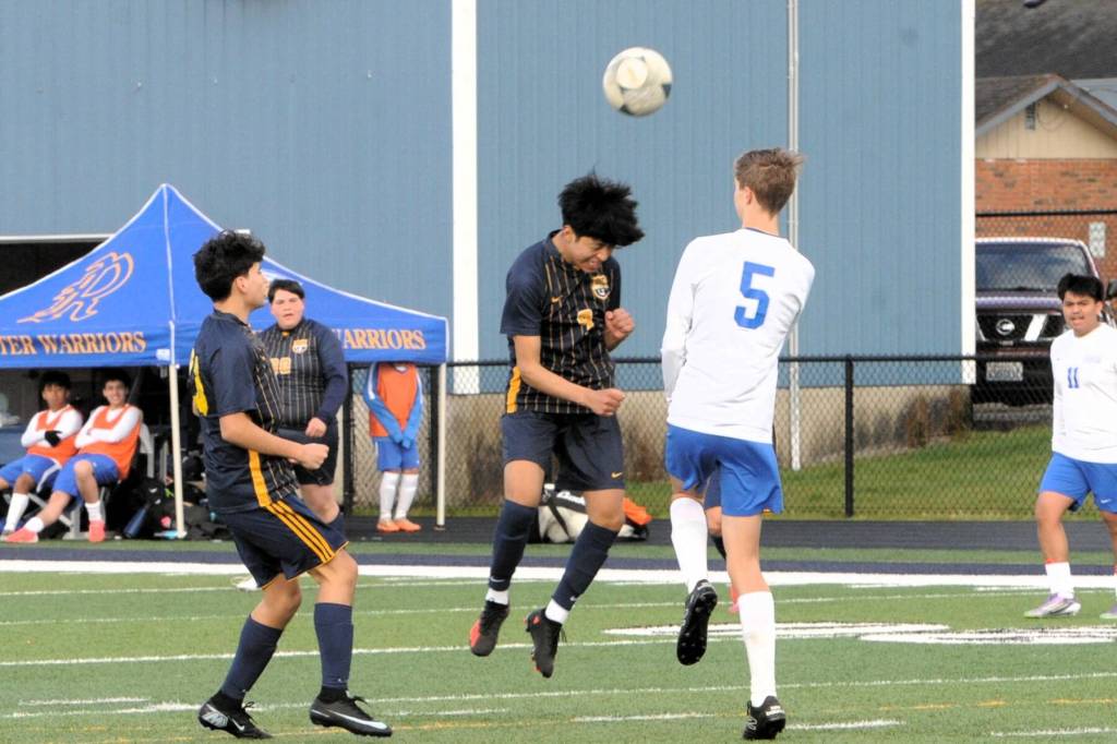 Forks Bernabe Calmo Cartillo with a header while Oscar Olivera looks on. 
Photo by Lonnie Archibald