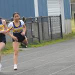 Forks Kim Camacho hands the baton to teammate Lizzy Morrison during the last leg of the 4X2 relay.