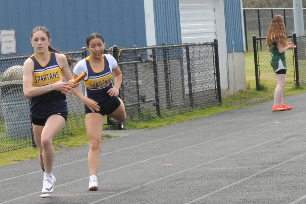 Forks Kim Camacho hands the baton to teammate Lizzy Morrison during the last leg of the 4X2 relay.