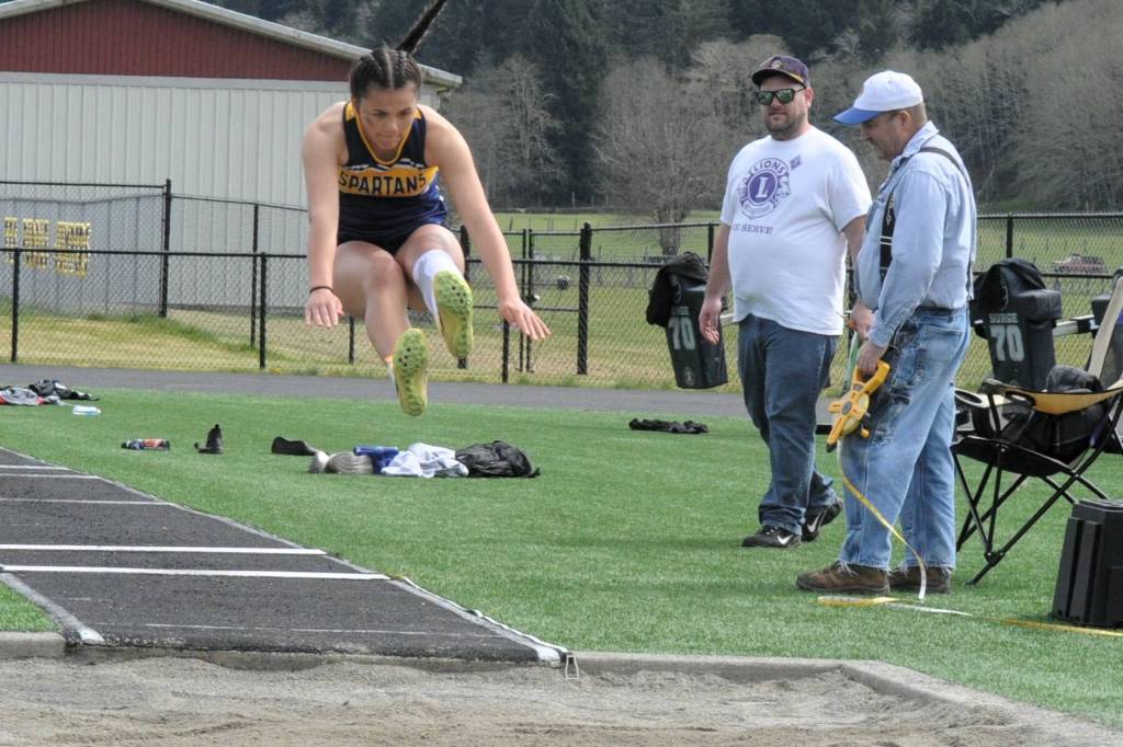 Forks Natasha Fletcher competed in the long jump. Looking on are Forks Lions Club members Joe Echeita and Ken Bechtold.
