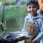 Aven Camocho, age 3, needed helping hands to hold this lunker he caught at the Washington State Fish and Wildlifes Bogachiel Hatchery during the annual Kids Fishing Day sponsored by the West End Sportsmens club along with other donors and volunteers.
