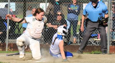 Forks catcher Fynlie Peters tags the Elma runner out at home assisted by a great throw from Spartan center fielder Bailey Johnson. Elma outlasted Forks winning 8 to 6 in a very well-played contest by both teams.