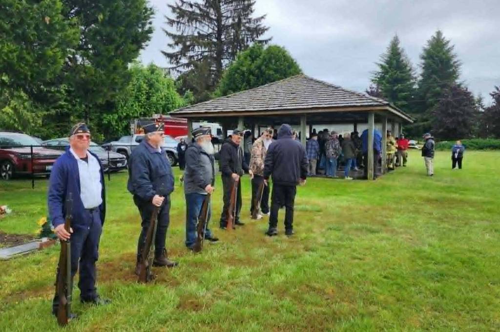 Photo Vern Hestand 
It quit raining …as the rifle squad got into position and Pastor Warren Johnson delivered his message outside the covered area at the cemetery.