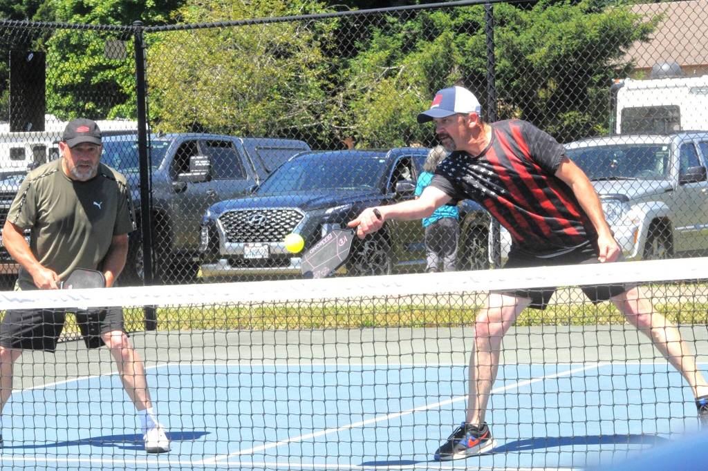 Steve Jewett hits while teammate Dave Gundel looks on during the Paddle Battle Pickleball Tournament held Sunday at Tillicum Park. The event was sponsored by West End Thunder.