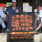 Photos by Lonnie Archibald 
Lions Club members Ken Bechtold and Josh Broo prepare baked salmon at the Ben Dome in Tillicum Park during the annual Forks Lions Club Salmon Bake.