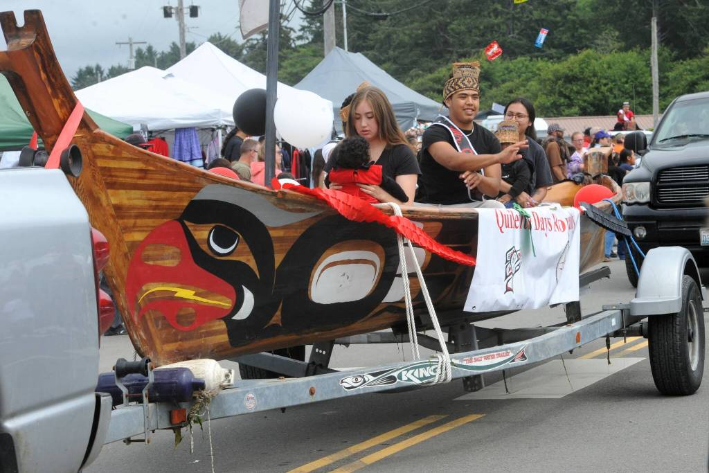 Quileute Days King Kaden Ward throws candy from a Quileute Canoe.